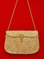 Gold embroidered handbag with a chain strap on a red background